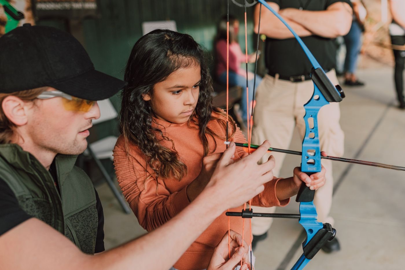 Instructor guiding a young archer